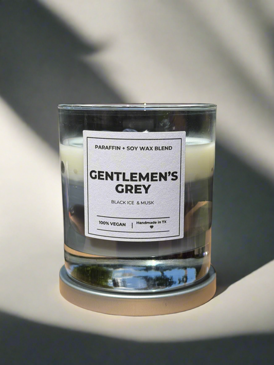 Candle labeled 'Gentlemen's Grey' with a label detailing wax blend and vegan certification.